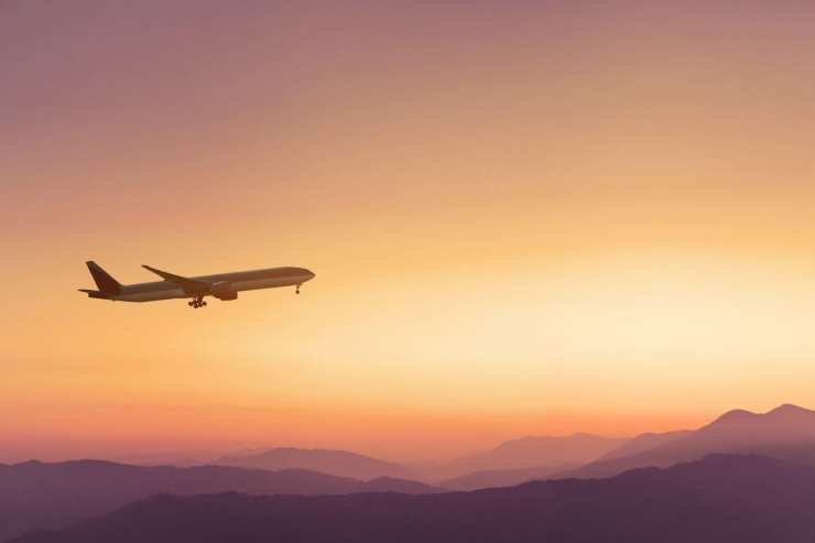 About us travel-airplane-in-sunset-sky